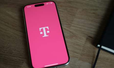 A pink phone sitting on top of a wooden table