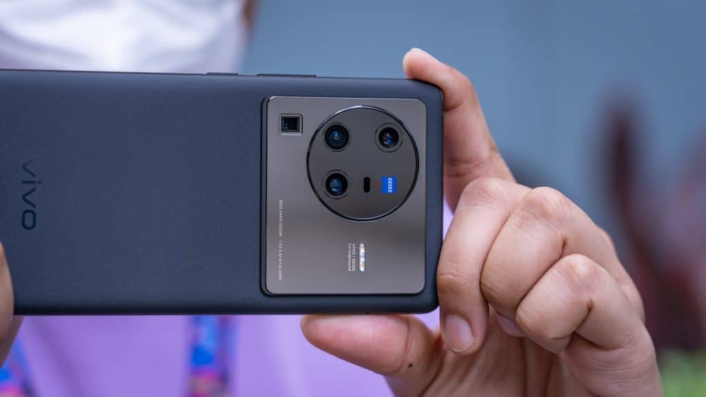 a hand holding a black and silver cell phone