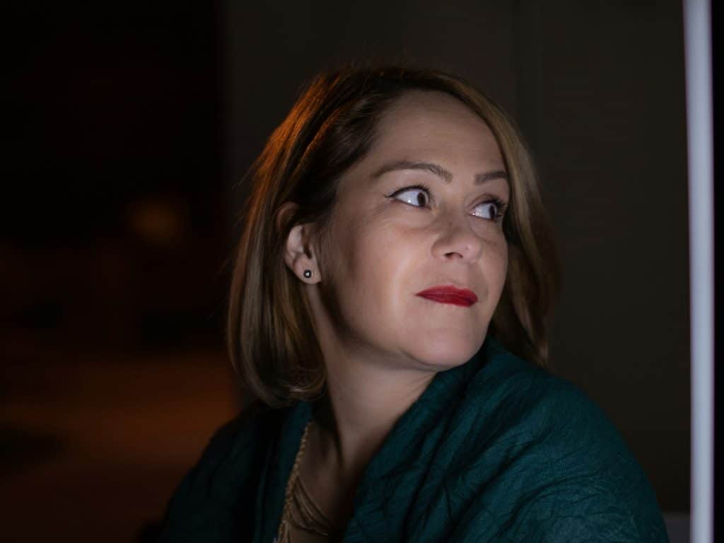 a woman in a green shirt looking up at something