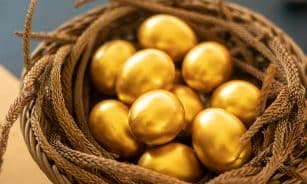 a basket filled with gold colored eggs on top of a table