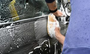 a man washing a car with a sponge