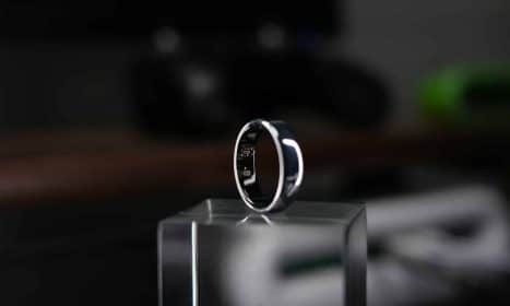 A smart ring is displayed on a clear block.