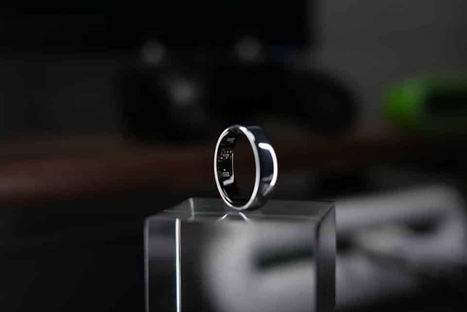 A smart ring is displayed on a clear block.