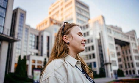 Woman poses in front of a building.