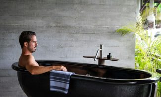 A man sitting in a black bath tub