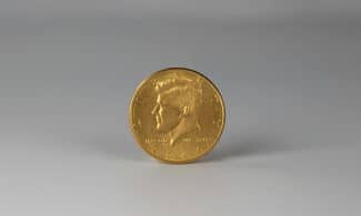 a close up of a gold coin on a white surface