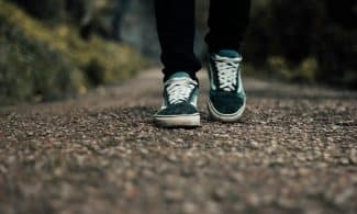 a person standing on a gravel road with their shoes on