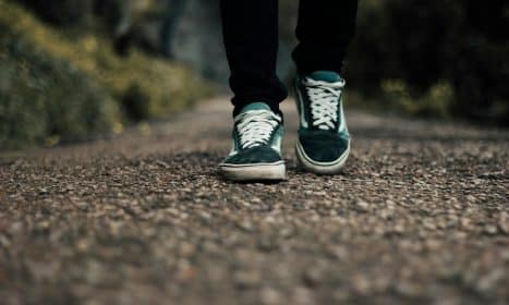 a person standing on a gravel road with their shoes on