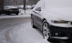 a car covered in snow on a snowy street