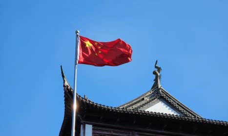 A chinese flag flying on top of a building