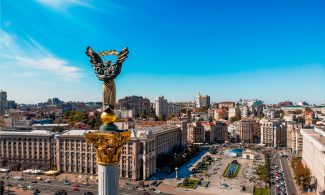 a view of a city with a statue in the middle