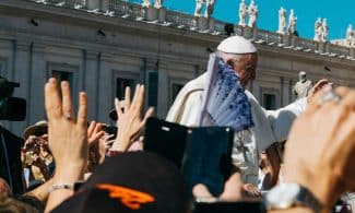 Pope surrounded with people during daytime