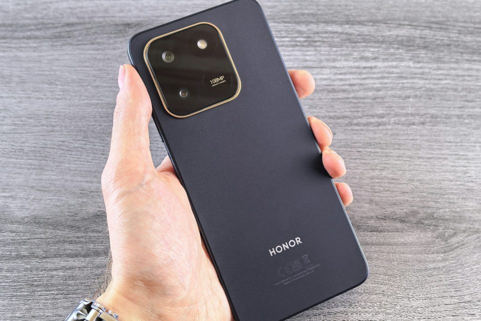 Hand holding a dark blue smartphone with camera module.