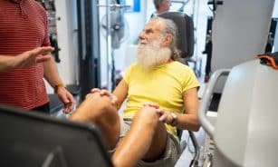 a man with a white beard sitting in a gym