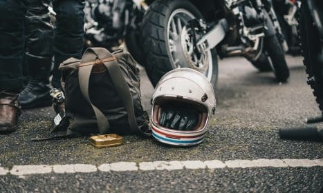 white helmet beside black backpack on road