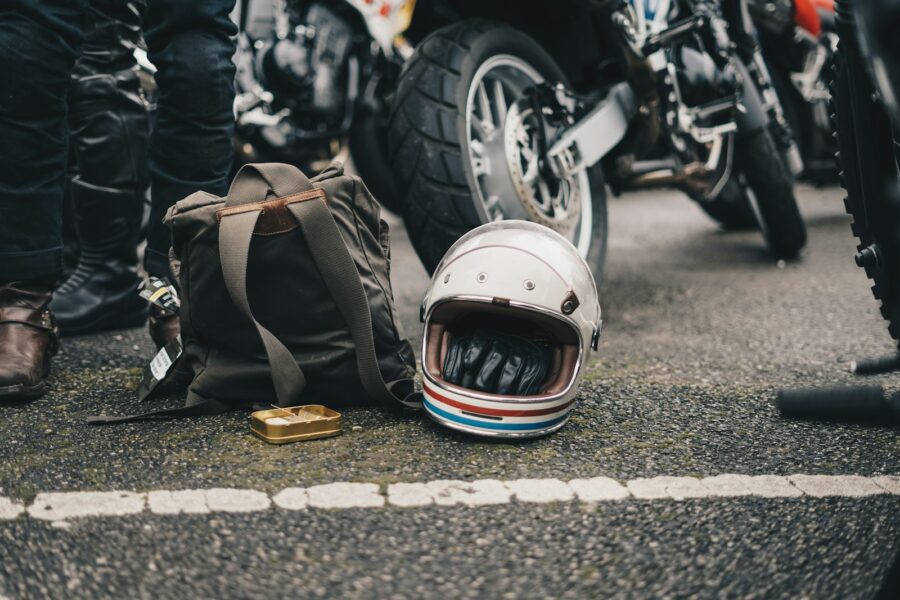 white helmet beside black backpack on road