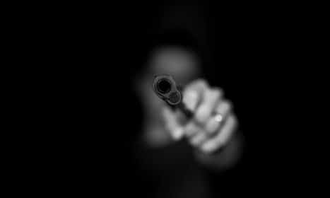 grayscale photography ofperson holding gun