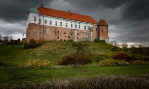 a large building sitting on top of a lush green hillside