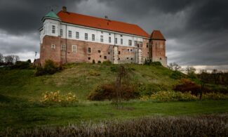a large building sitting on top of a lush green hillside