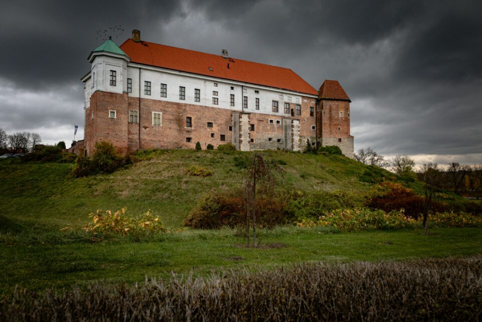 a large building sitting on top of a lush green hillside