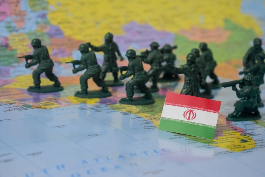 Toy soldiers on a map with iran flag.