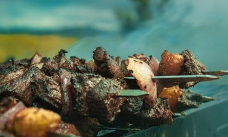 A close up of a skewer of food on a grill
