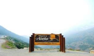 brown wooden signage on gray sand during daytime