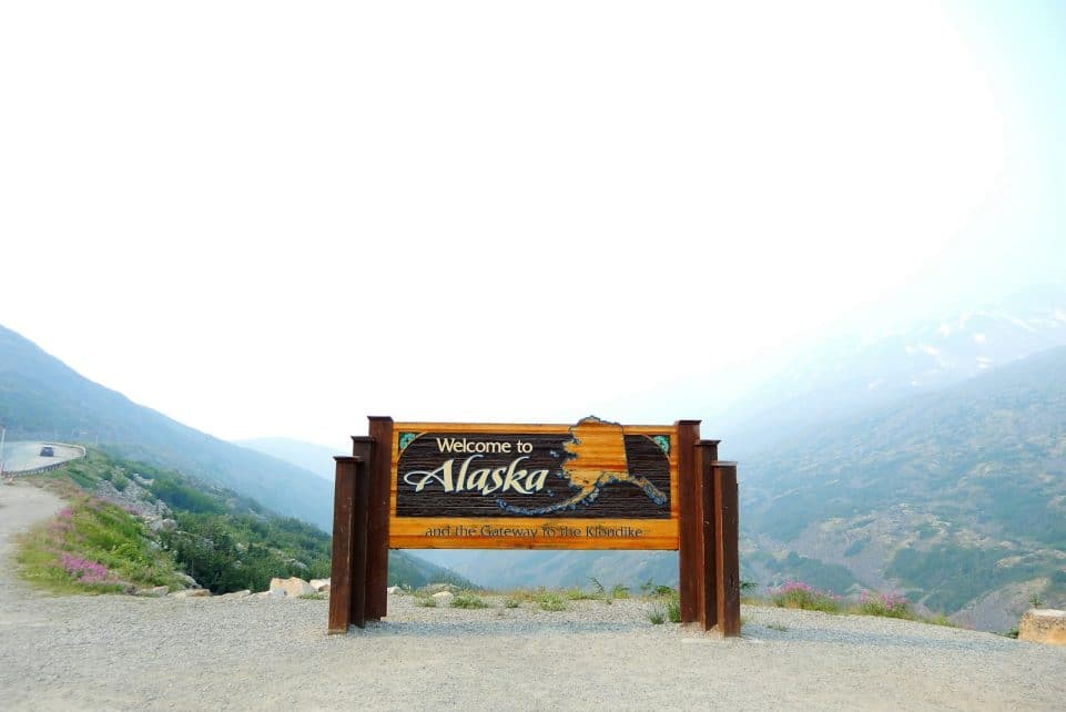 brown wooden signage on gray sand during daytime