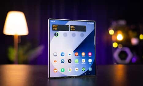 A cell phone sitting on top of a table next to a lamp