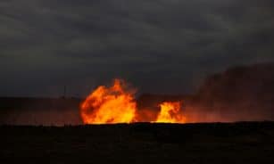 Flames erupting from the ground at dusk
