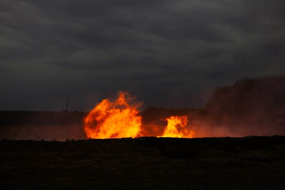 Flames erupting from the ground at dusk