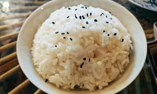 a bowl of white rice with black sesame seeds