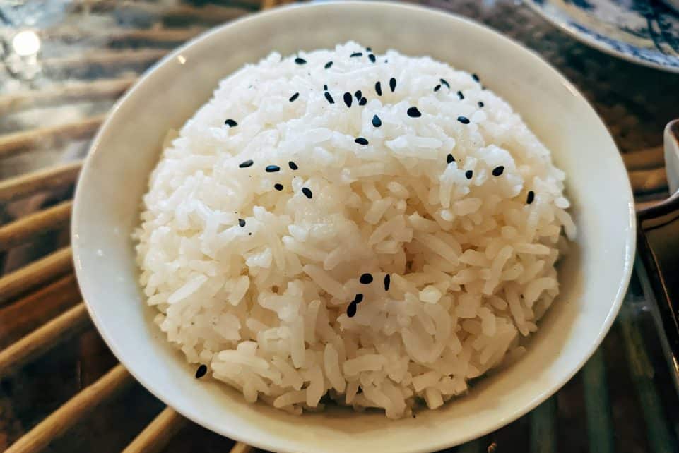 a bowl of white rice with black sesame seeds