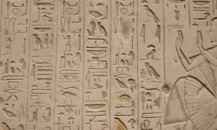 a close up of a wall with egyptian writing on it
