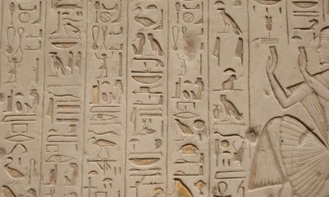 a close up of a wall with egyptian writing on it