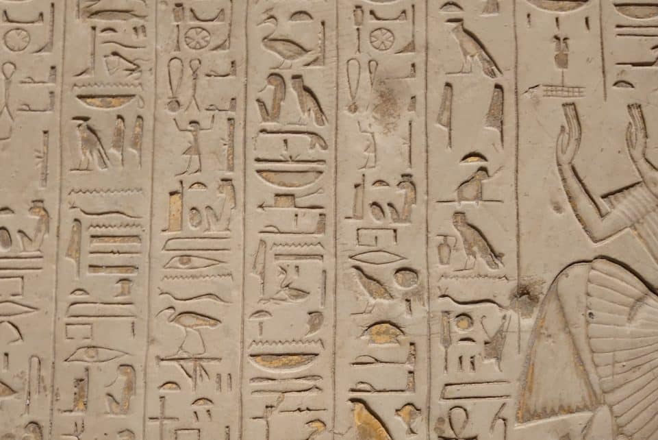 a close up of a wall with egyptian writing on it