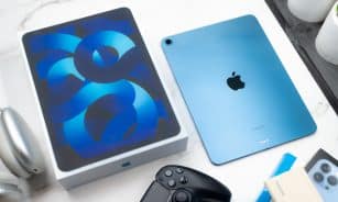 a table topped with an ipad and a controller