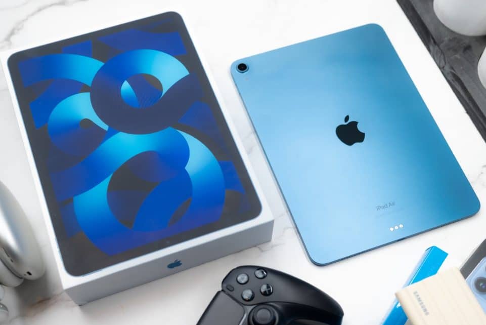 a table topped with an ipad and a controller