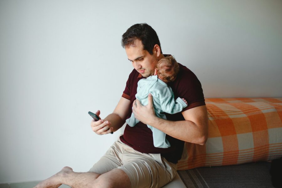 man in green shirt carrying baby