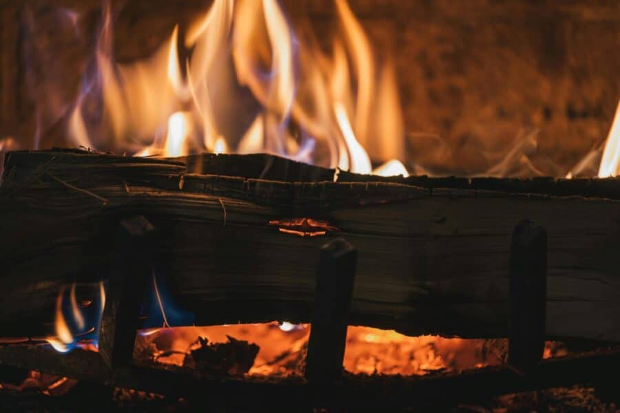 A close-up view of a cozy fireplace with burning firewood and vivid flames.