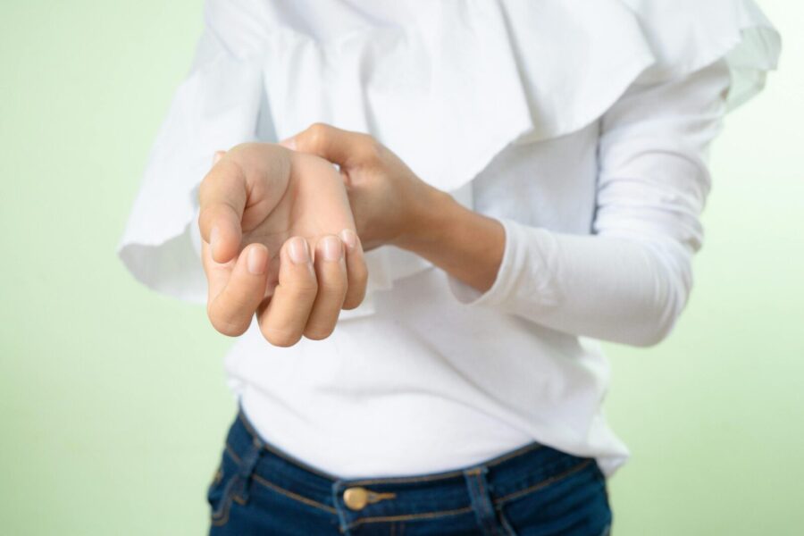 Close-up of a woman's hands and white shirt sleeves in a casual pose. Ideal for lifestyle and fashion themes.