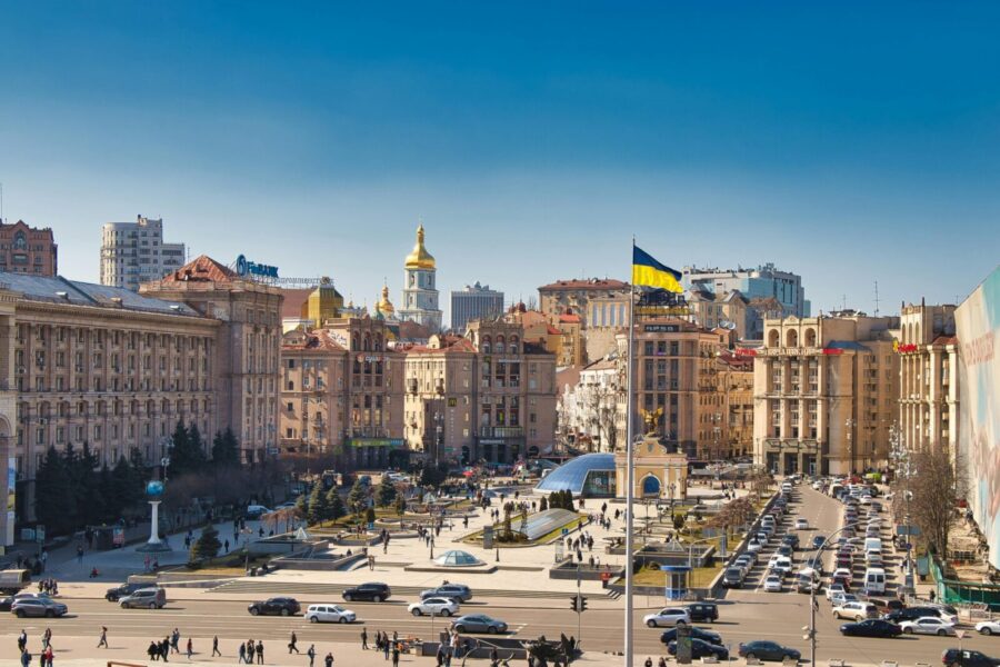 A bustling daytime scene at Independence Square in Kyiv, Ukraine, showcasing historical architecture and city life.