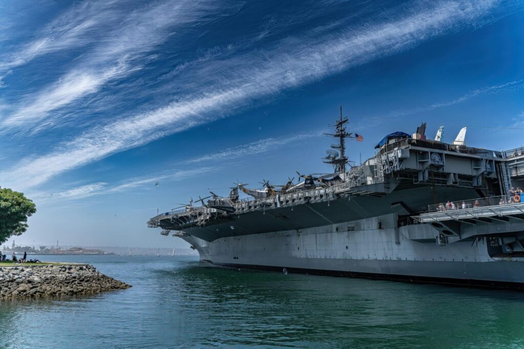 USS Midway Museum ship docked in San Diego harbor on a clear day, showcasing naval history.