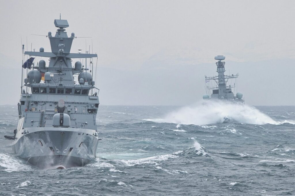 Navy warships navigating turbulent ocean waters showcasing maritime strength.