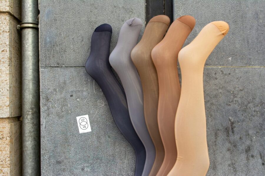 Five colored stockings on a concrete backdrop showcasing diversity in fashion.