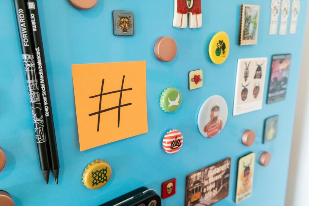 Close-up of magnets and a sticky note on a blue fridge surface.