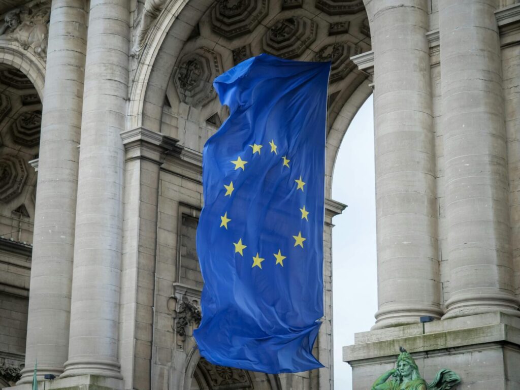 European Union flag fluttering beneath the Cinquantenaire Arch in Brussels, Belgium.