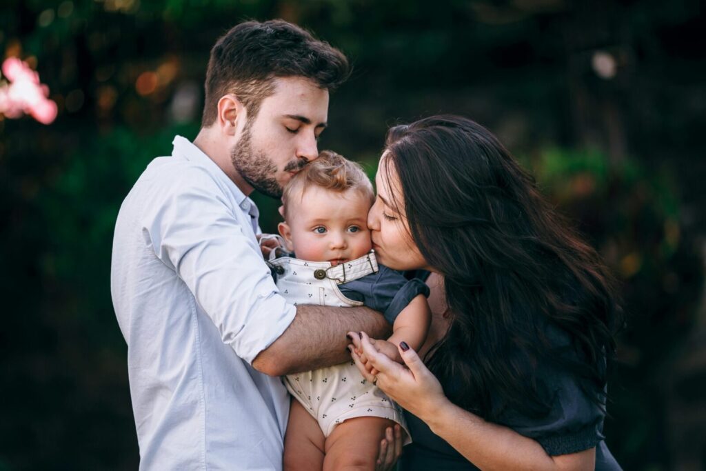A heartwarming outdoor portrait of a loving family embracing their baby.