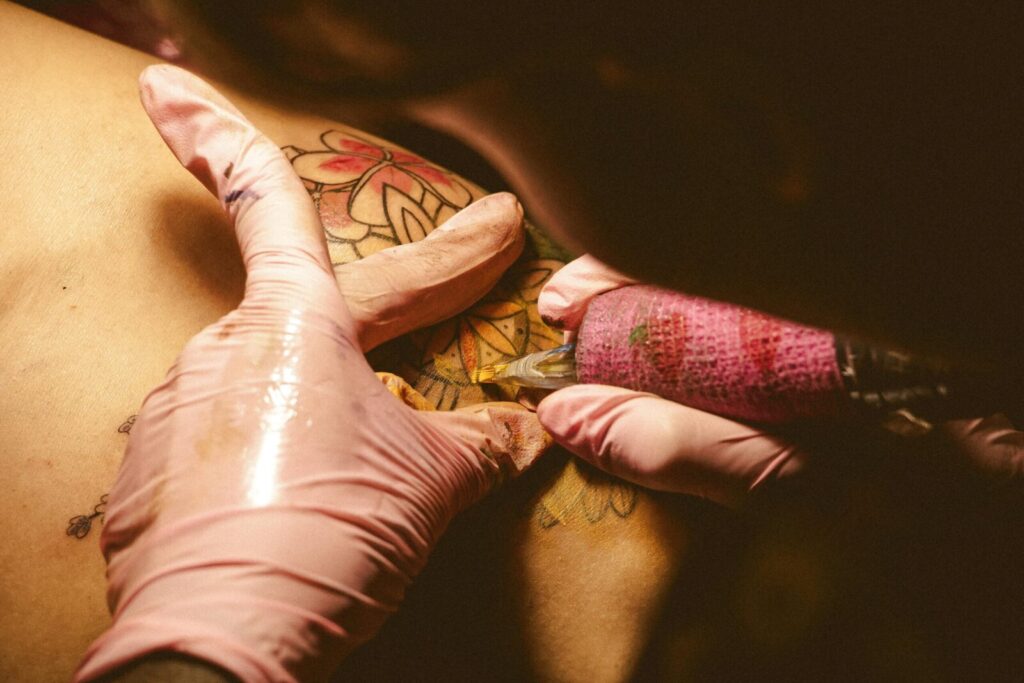 A detailed image showing a tattoo artist at work, capturing the intricate tattooing process.