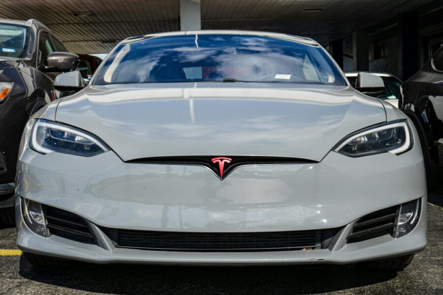 Front view of a Tesla Model S parked in an urban area, highlighting sleek design and modern aesthetics.